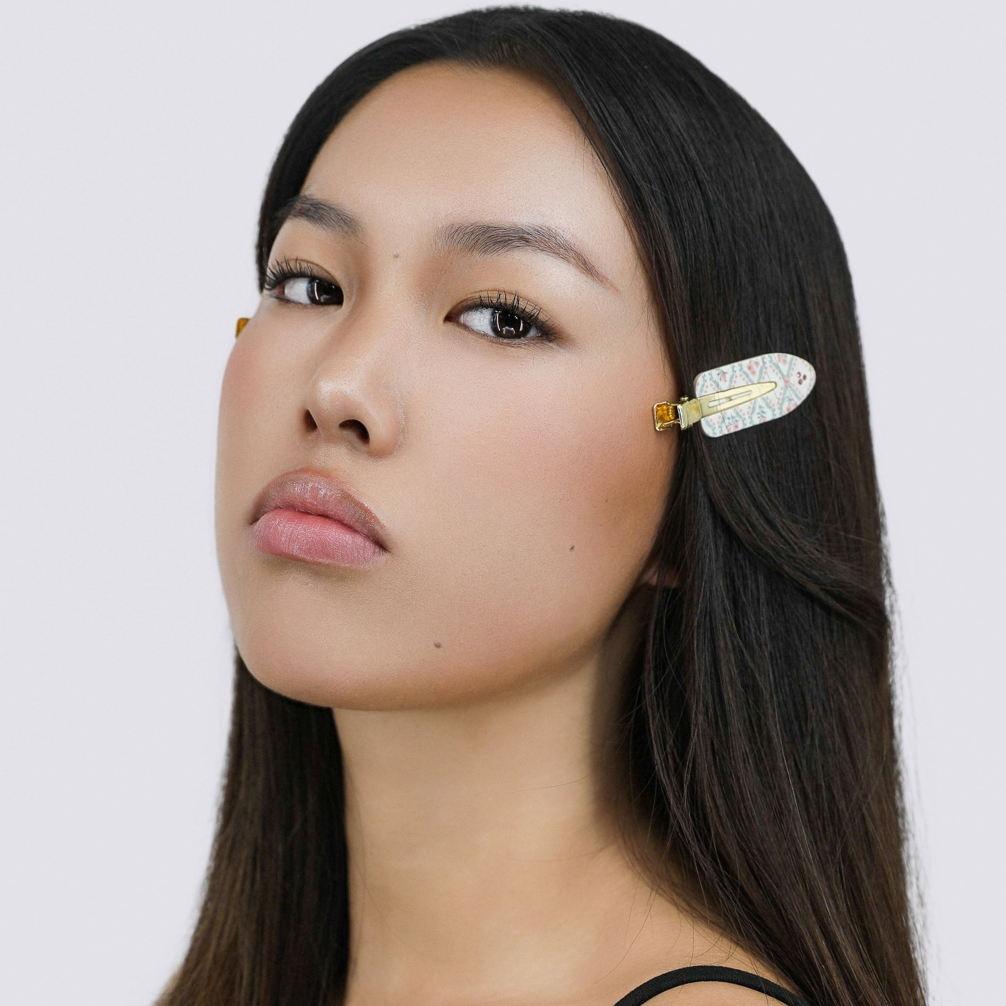 Hamie with a Luna Wave white rose lattice hair clip on a plain background