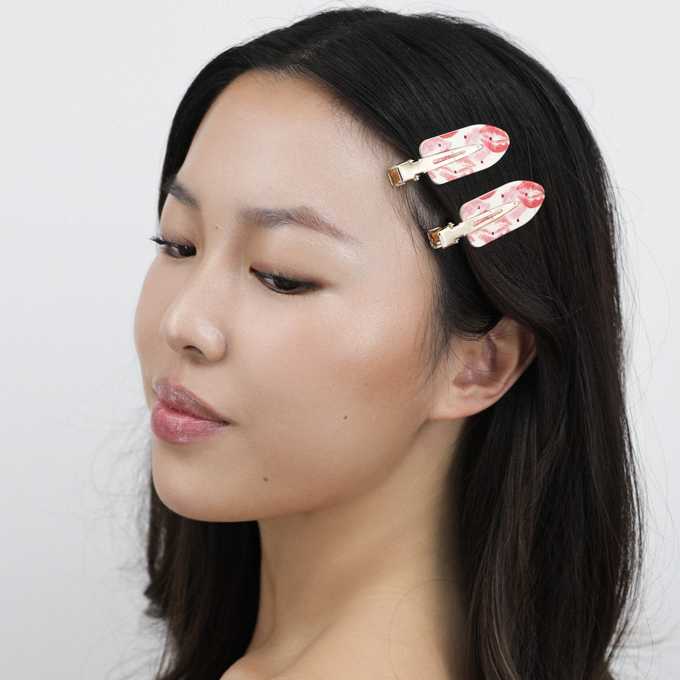 Hamie with long brown hair wearing Luna Wave pink rosy hair clips against a white background