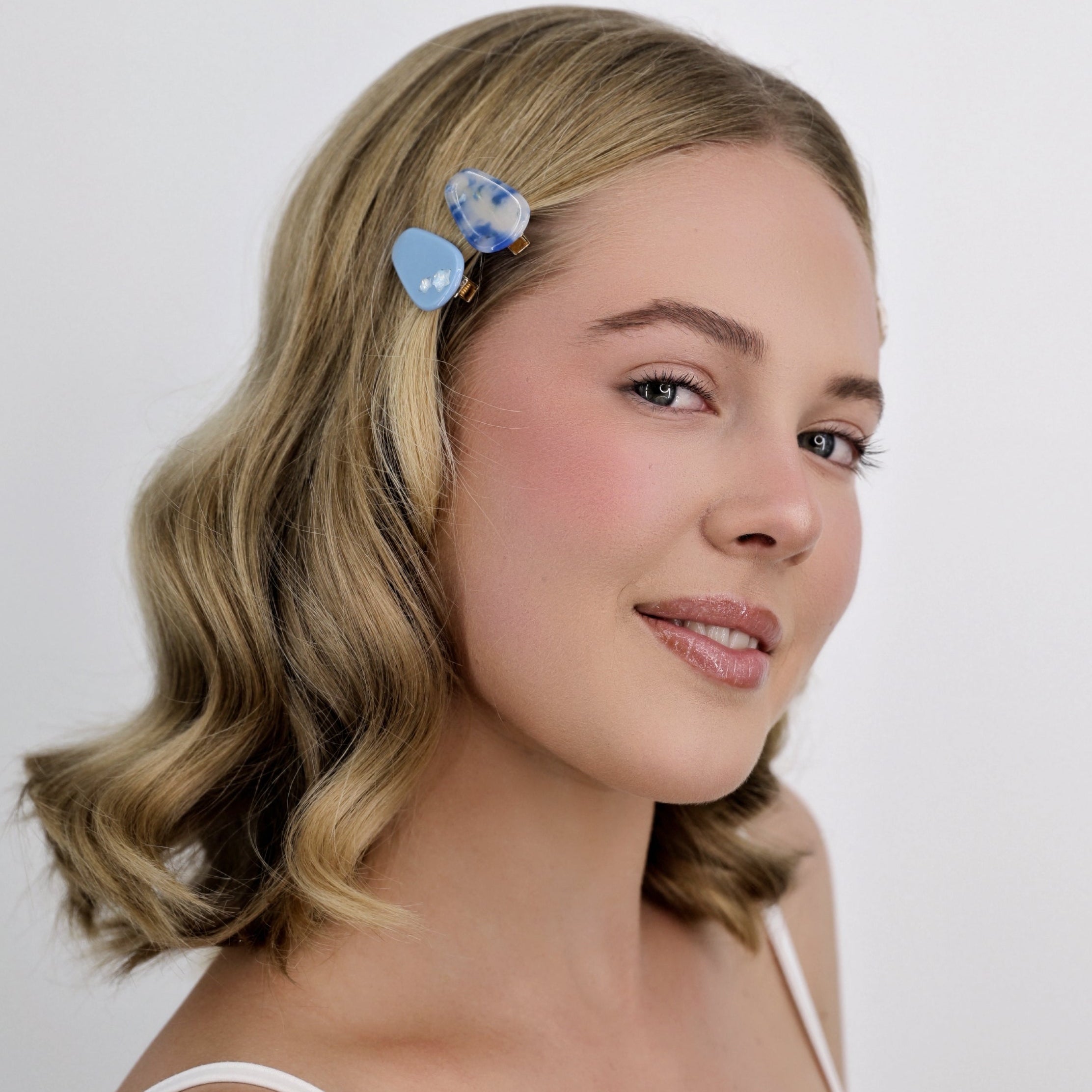 Woman with a Luna Wave blue sky petite hair clips on a plain background