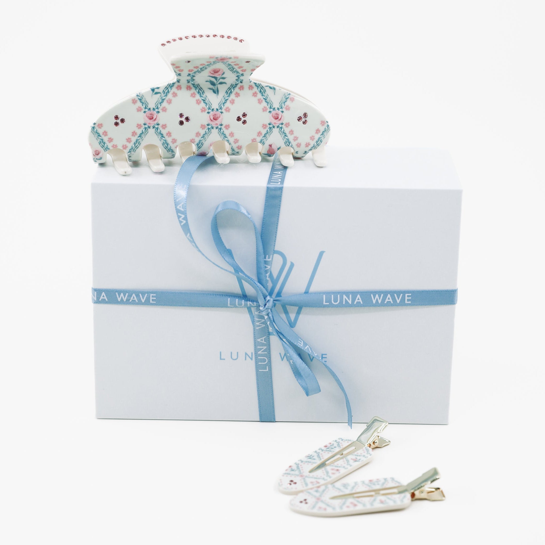 Decorative headband and hair clips with a branded box on a white background