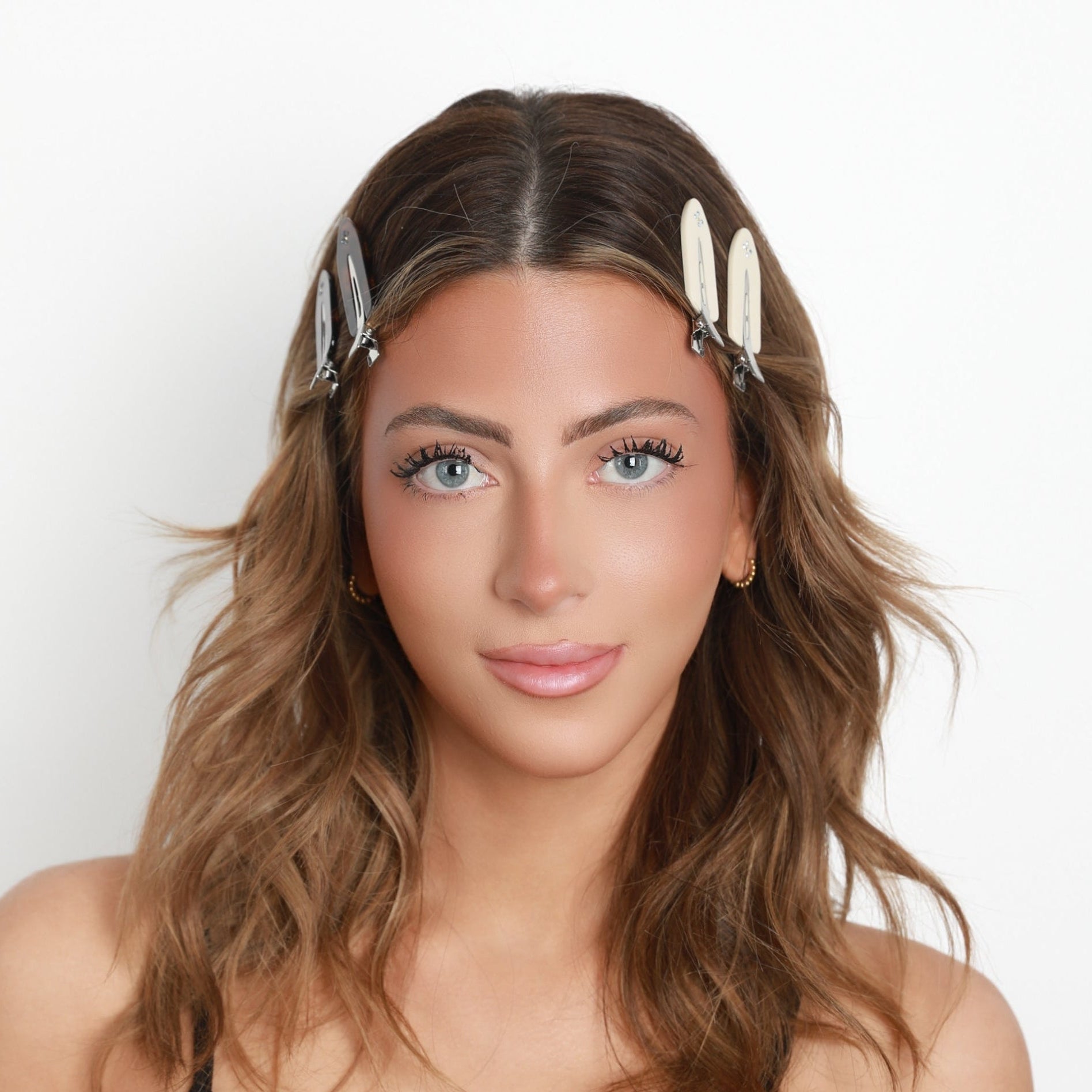 Woman wearing Luna Wave starlet hair clips with a plain background