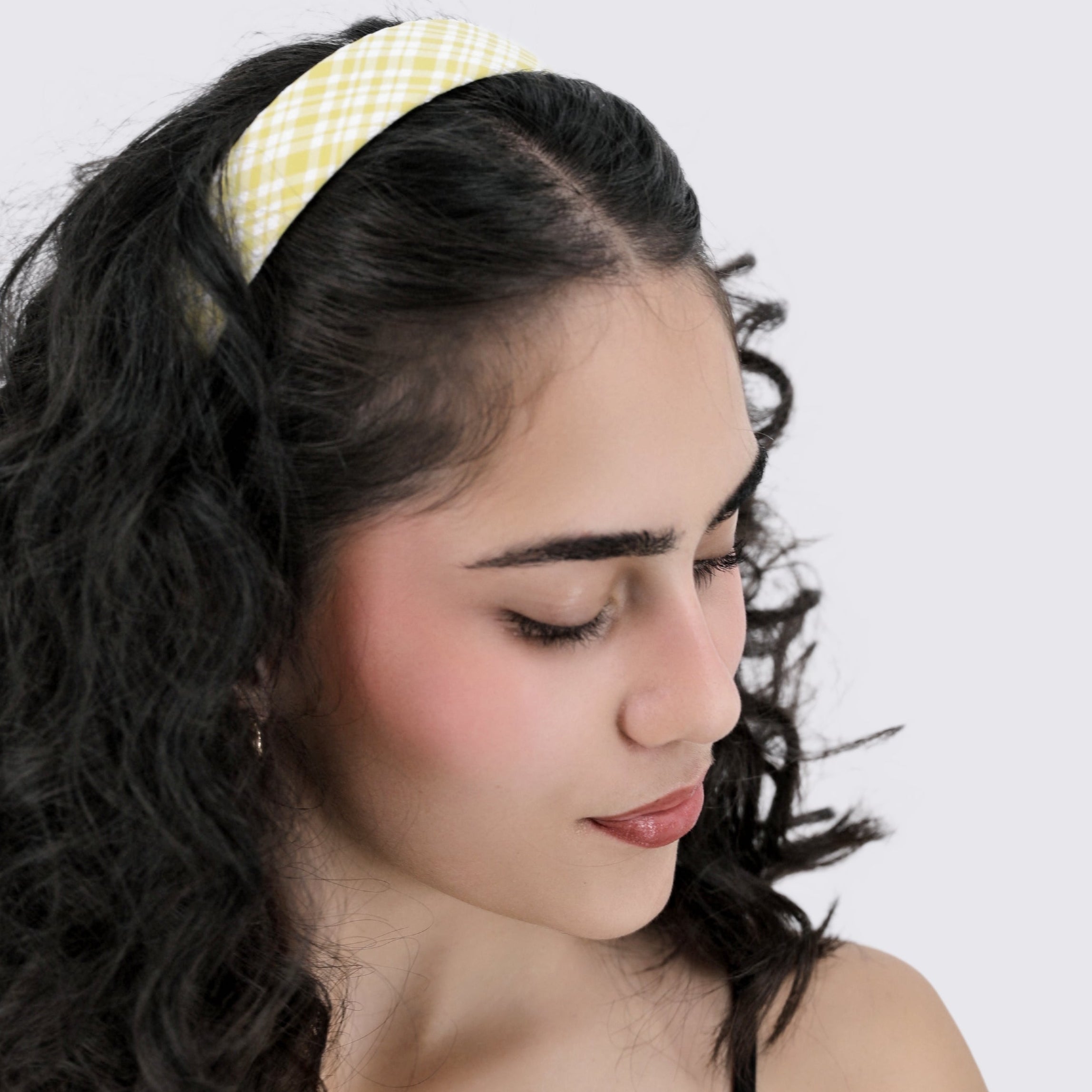 Woman with styled hair wearing a Luna Wave yellow lemon gingham headband against a white background